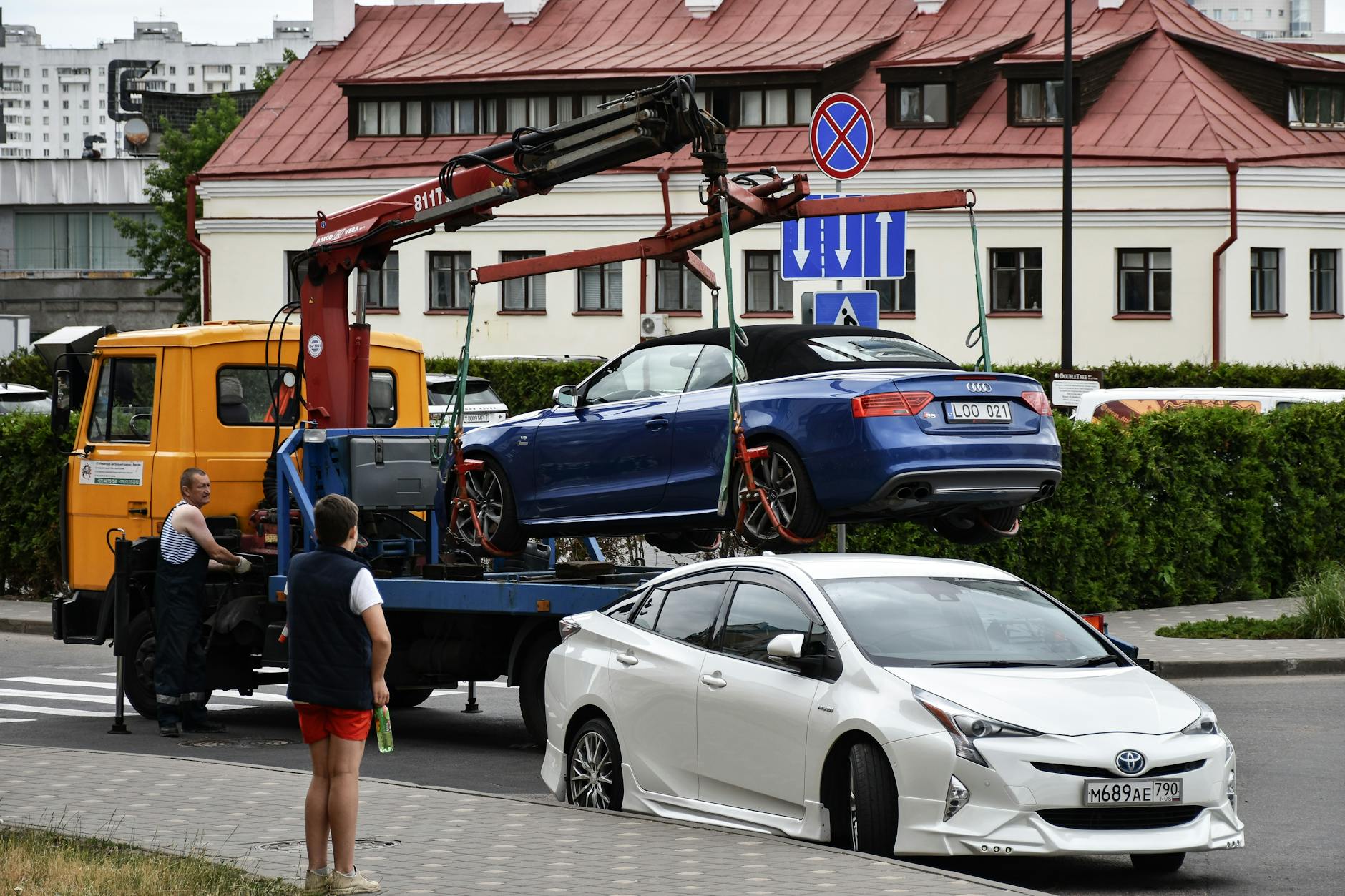 Czy można holować samochód osobowy na autostradzie co dokładnie mówią przepisy i jakie są bezpieczne alternatywy Holowanie niebieskiego kabrioletu Audi na ruchliwej miejskiej ulicy