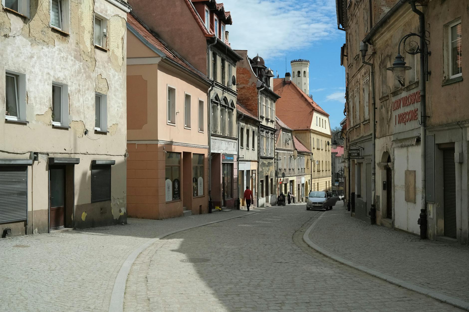 Brukowana uliczka i zabytkowe kamienice w małym polskim miasteczku
