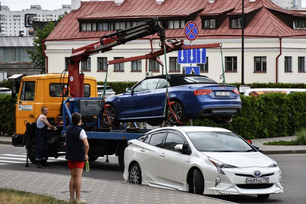 Holowanie niebieskiego Audi kabrioletu na ruchliwej ulicy miasta