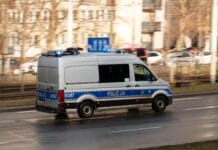 Polski radiowóz na sygnale na miejskiej drodze